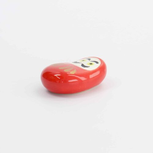 Origineel Tokyo Design Studio ontwerp Kawaii stijl met Daruma decoratie Handig formaat: 3.0x4.4x1.6 cm Houdt eetstokjes hygiënisch op hun plaats Tokyo Design Studio - Kawaii - Chopstick Legger - Daruma Strip - 3.0x4.4x1.6cm